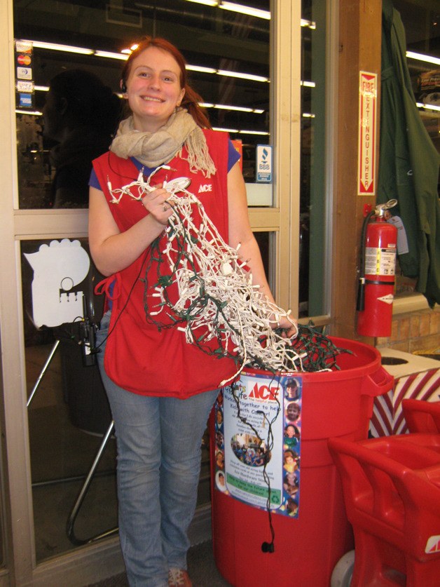 Ace Hardware employee Erin Ayriss holds up strands of broken holiday lights