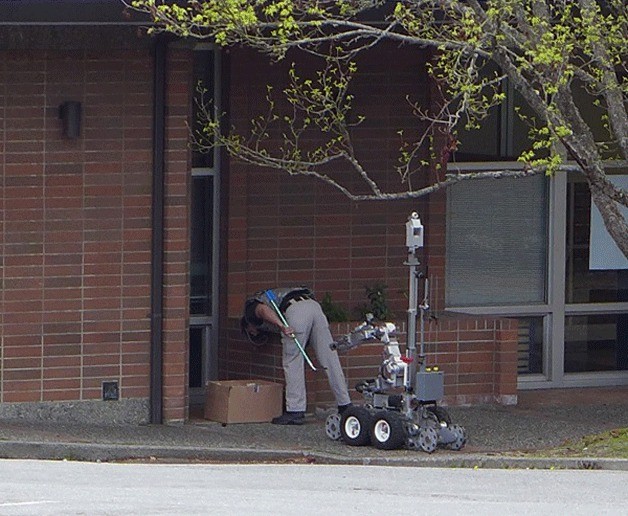 A Bremerton-based bomb squad inspects the suspicious box at the Winslow Post Office.