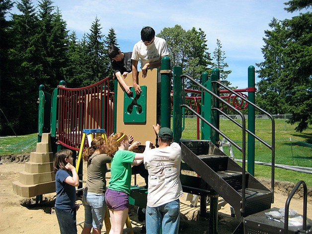 Volunteers work alongside district staff to install the Strawberry Hill Park playground