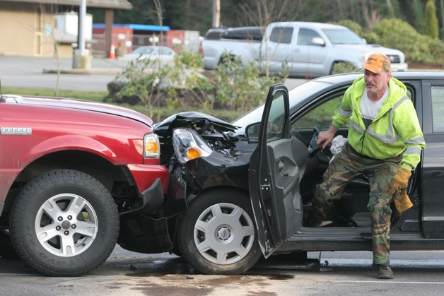 Cory Meek of Gateway Towing readies a Toyota Scion for towing after a two-car accident Thursday on Madison Avenue.