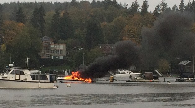 A boat in Eagle Harbor is engulfed in flames Saturday morning.