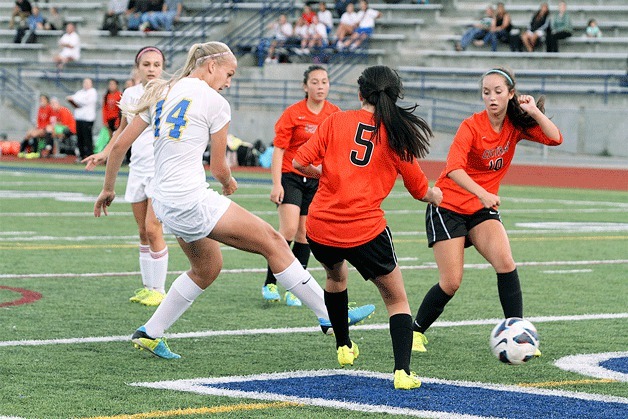 Kamie Coryell slips her first goal through two Cougar defenders during the Spartans’ win over Central Kitsap Tuesday.
