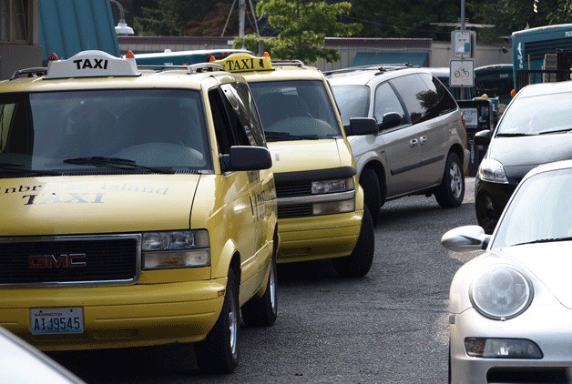 Drivers hoping to pick up people at the Bainbridge Island Ferry Terminal maneuver past the taxi stand on the cramped driveway at the terminal.