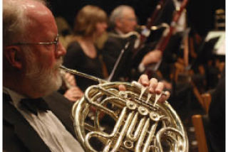 Bainbridge Symphony Orchestra member Ken Mueller on French Horn.