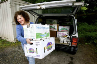 Quilcene based Chris Llewellyn delivers fresh organic produce to the Bainbridge Helpline House Friday. Her farm