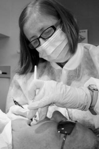 Kate Mills of Washington State Smile Partners checks the teeth of patient Mary Joan Zakovy