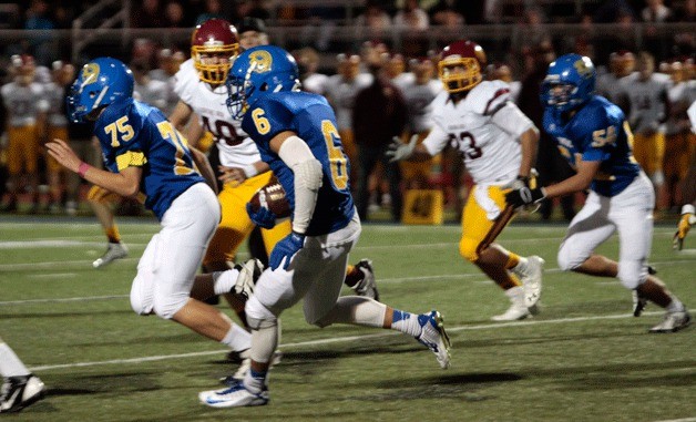 BHS senior running back Ben Fisher skirts around the defensive efforts of the visiting O'Dea High Friday
