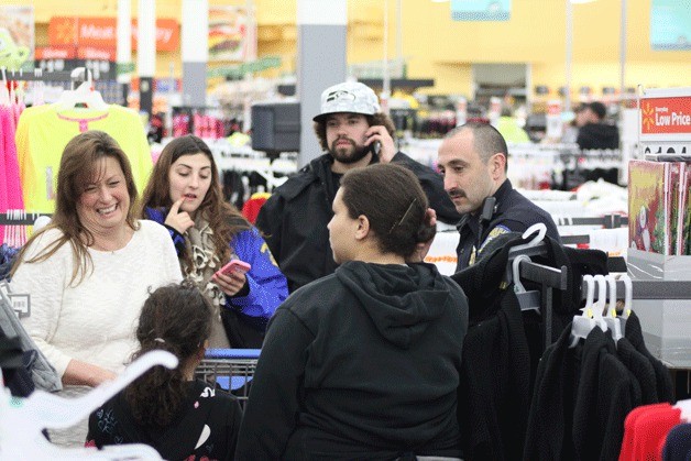 Bainbridge Police Officer Victor Cienega peruses the aisles at Walmart in Poulsbo with his shopping crew during the recent Shop with a Cop program.