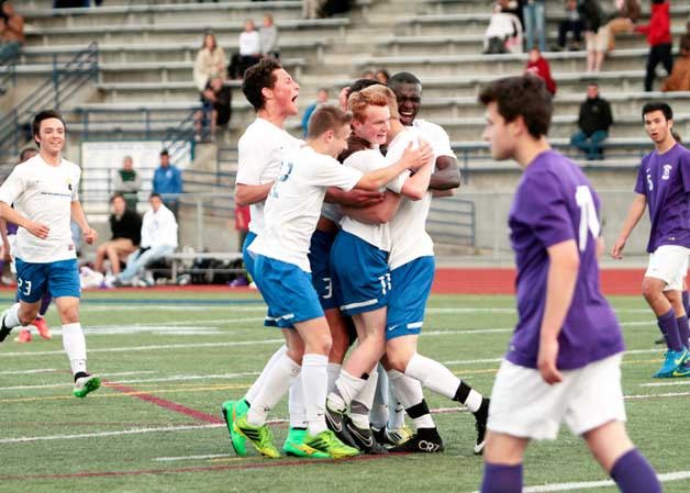 The BHS varsity boys soccer team come together for a celebratory embrace after Finn Delphinidae scored the goal that put Bainbridge up 2-1 for the win in Monday’s match against Garfield.