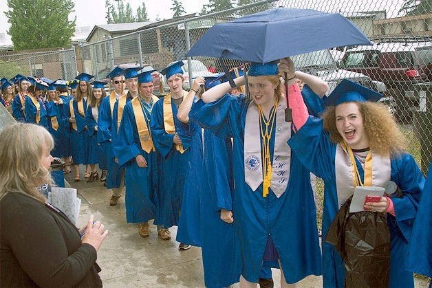 Graduates line up in the rain Saturday