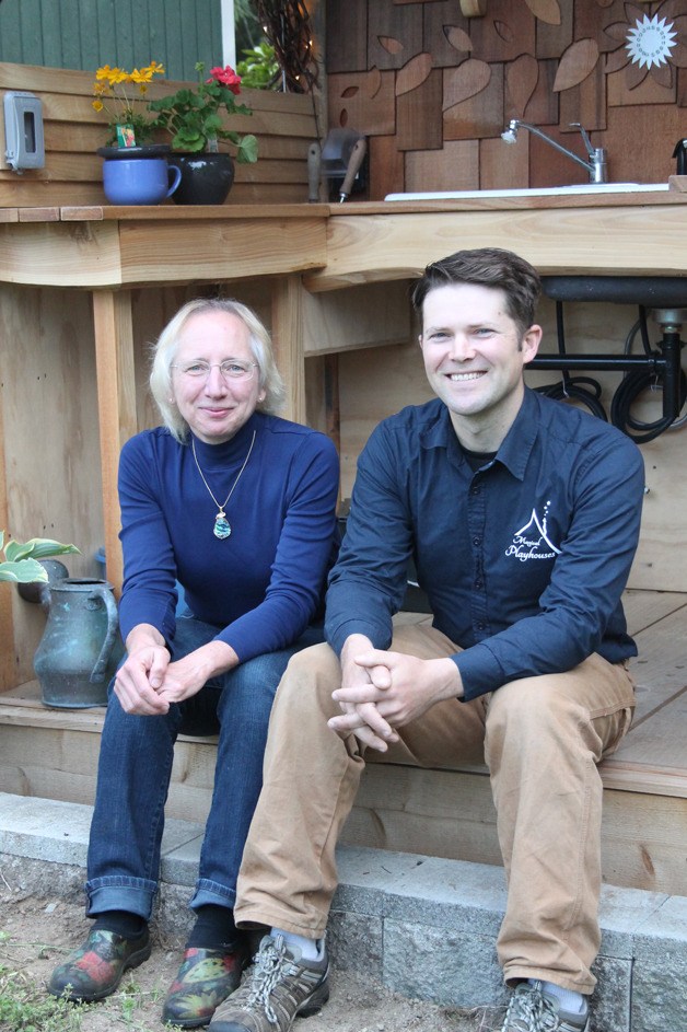 Deb Fenwick sits with magical playhouse builder Chris Axling on the steps of a custom-made garden shed that Axling built.