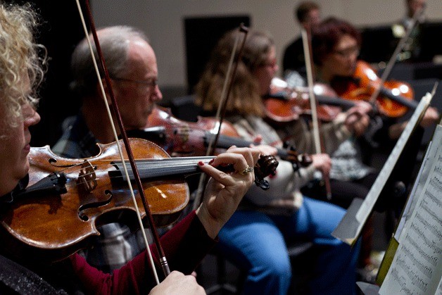 A portion of the string section of the Bainbridge Symphony Orchestra works through a recent practice session in preparation for their season opener production.