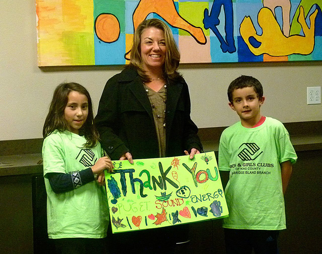 Photo courtesy of Liam McEvilly                                Boys & Girls Club kids thank Puget Sound Energy 
outreach manager Karen Brubeck for the company’s $5,000 donation.