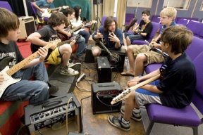 Rock Camp instructor and guitarist Justin Davis (center) works with students on a riff from AC/DC’s “Back in Black.”