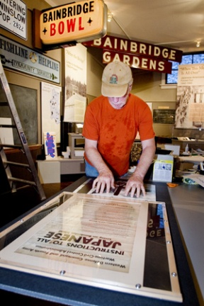 Bainbridge Island Historical Museum Facilities Manager Rick Chandler prepare exhibits for this Sunday’s grand re-opening ceremonies.