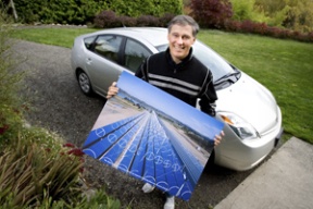 Congressman Jay Inslee with his Prius and a photo of a solar plant he toured.