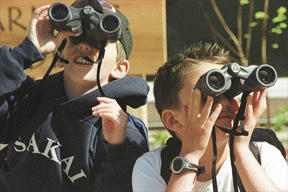 Kyle Schneider and Dominic Crowley try out their binoculars after a presentation called A Tale of Two Owls.