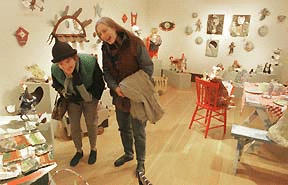 Artists Sally Prangley Rooney (left) and Robyn Krutch admire their “Holiday Magic” creations at the Bainbridge Arts and Crafts exhibit. The exhibit runs Dec. 7 through Jan. 6.
