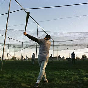 Adam Knappe swings for the batting cage netting.