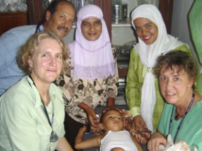 Dr. Linda Warren (left foreground) tends to a sick child in Sumatra