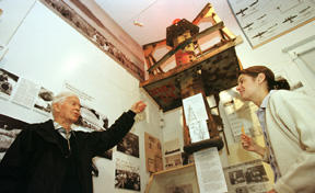 Rolling Bay resident Bill Weld and museum curator Erica Varga discuss the crown of the Fort Ward radio tower