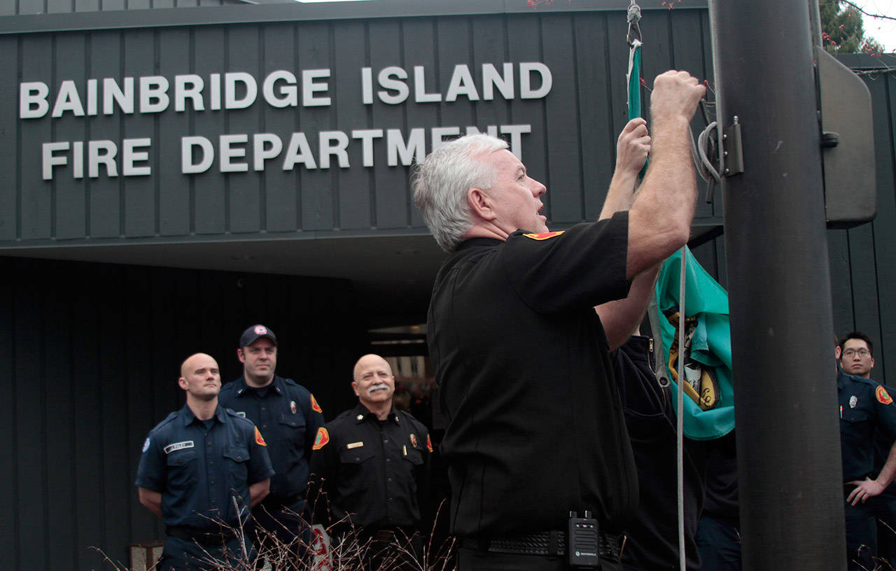 Luciano Marano | Bainbridge Island Review — Bainbridge Island Fire Department Battalion Chief Dave Hannon lowers the flag outside Station 21 for the last time, the department’s headquarters having been relocated to Station 23 on Phelps Road for the duration of the construction of a new facility. Hannon began his career with the BIFD in 1975 as a volunteer at the Bucklin Hill Road station and served for the longest of any island firefighter at Station 21.