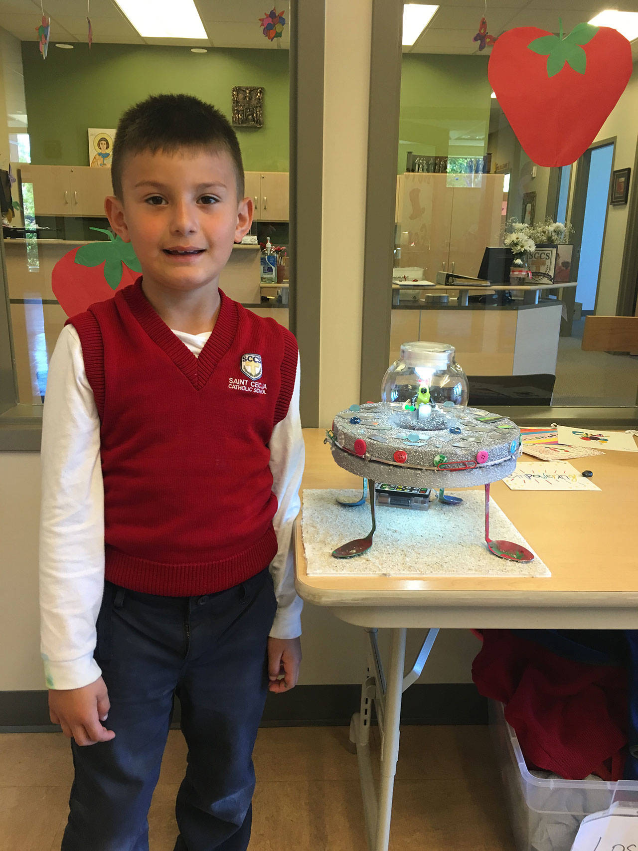Photo courtesy of  Susan Kilbane                                Jayden Larios, 6, a kindergartener at Saint Cecilia School, stands with his creation, the grand prize winner at the school’s recent 3-D “Star Wars”-themed recycled art show and photography competition.
