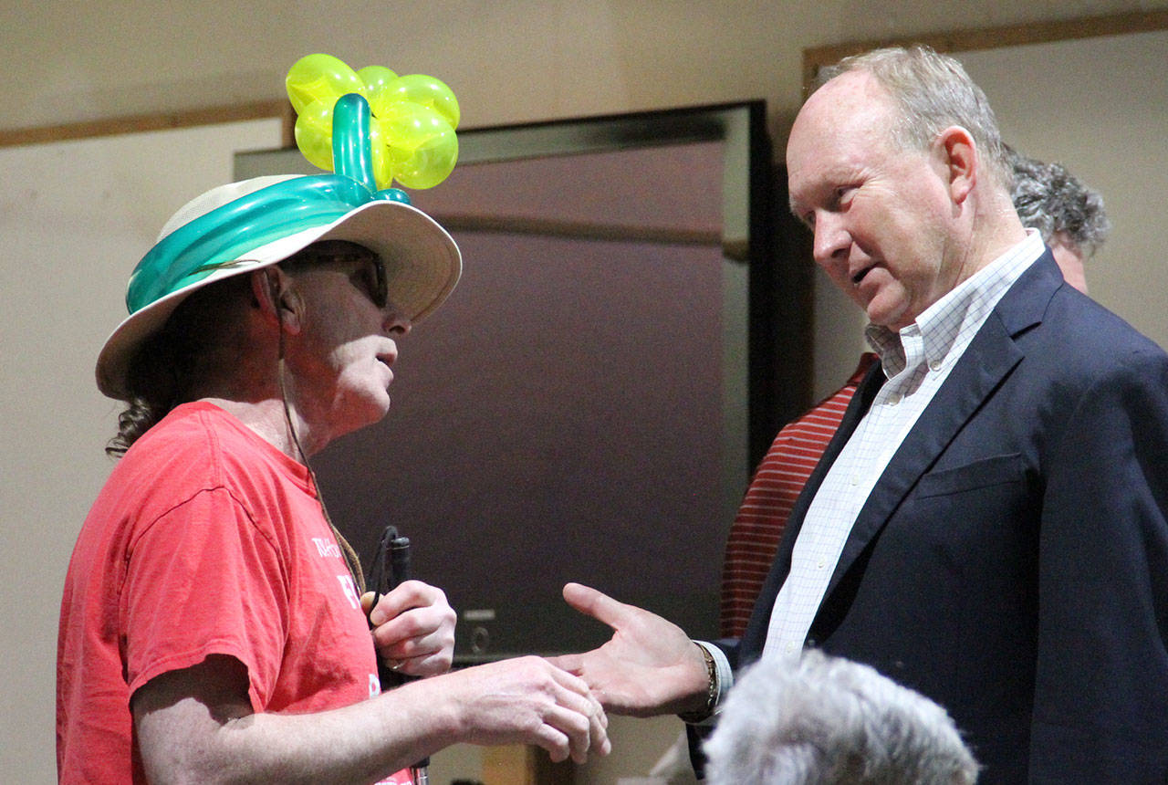 Jerry Brader Jr., a Bainbridge resident who performs as Majick The Clown, shares his concerns about a proposed ban on the sale and use of balloons with Councilman Mike Scott during a break in Tuesday’s council meeting. (Brian Kelly | Bainbridge Island Review)