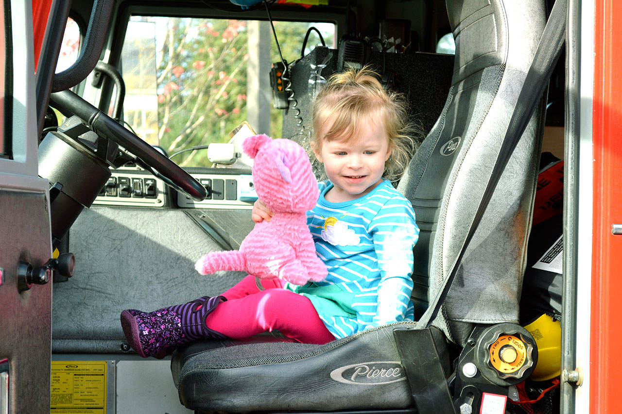 Colette and her cat are ready to drive the firetruck. (Mark Krulish/Kitsap News Group)