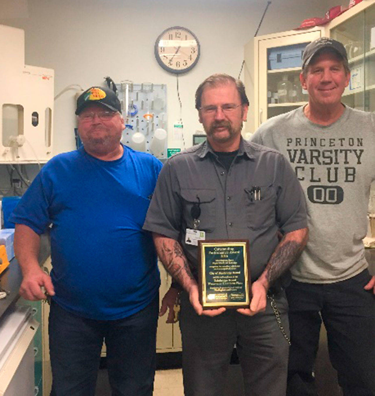 Bainbridge wastewater treatment plant employee Steve Pyke (center) holds the Wastewater Treatment Plant Award given to the city by the state Department of Ecology. Pyke is joined by fellow employees Delbert Frantz, and Doug Otte. (Photo courtesy of the city of Bainbridge Island)