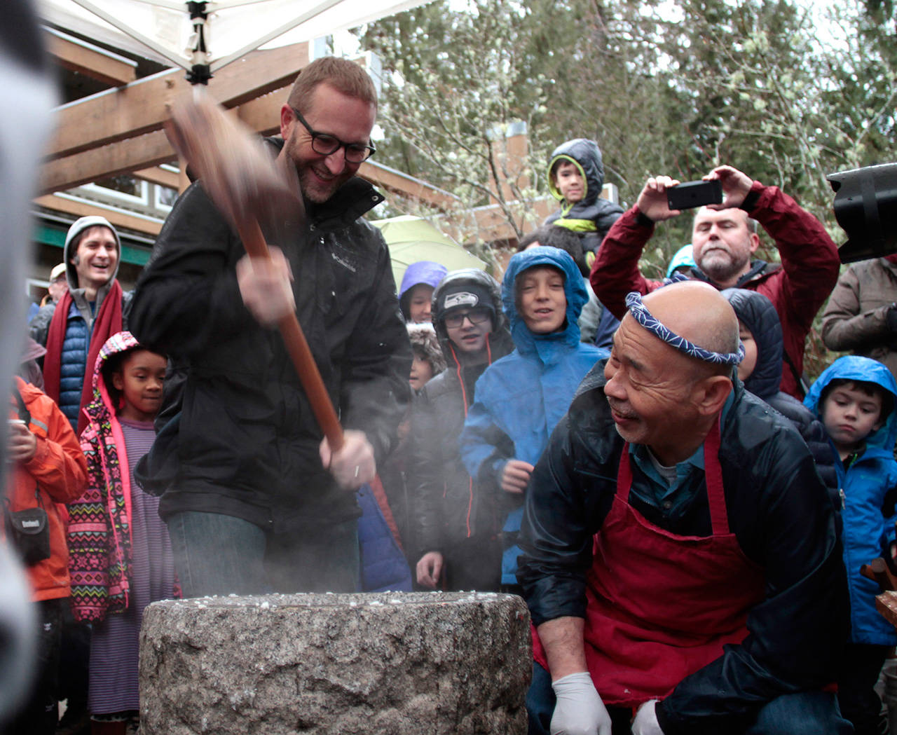 A visitor to last year’s event takes a turn at pounding rice into mochi. (Luciano Marano | The Bainbridge Review)