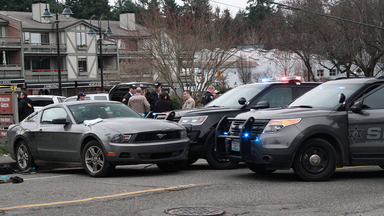 Law enforcement officers gather around a Ford Mustang that was driven by a man who fled from police during an emergency call at Ordway Elementary Wednesday afternoon; the driver was shot by a Bainbridge officer after his car was stopped in downtown Winslow. (Luciano Marano | Bainbridge Island Review)