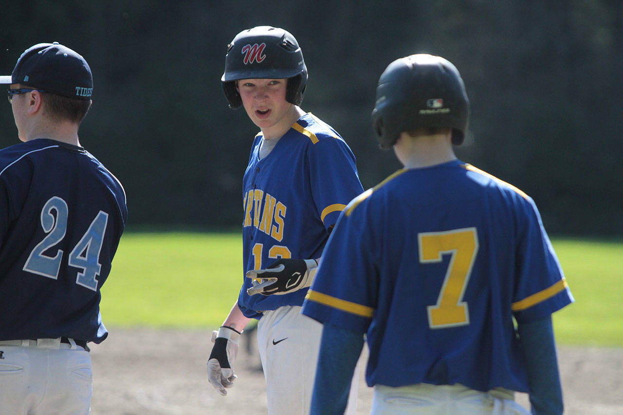 Thomas Murphy chats with a teammate from his perch on first base during the Spartans’ non-league matchup against Gig Harbor. (Brian Kelly | Bainbridge Island Review)