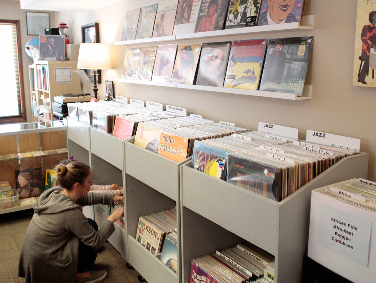 Luciano Marano | Bainbridge Island Review - Shoppers peruse the main rack of records at Backstreet Beat. Both that shop and Sound City Records will be open early and awash with specials for Record Store Day on Saturday, April 21.