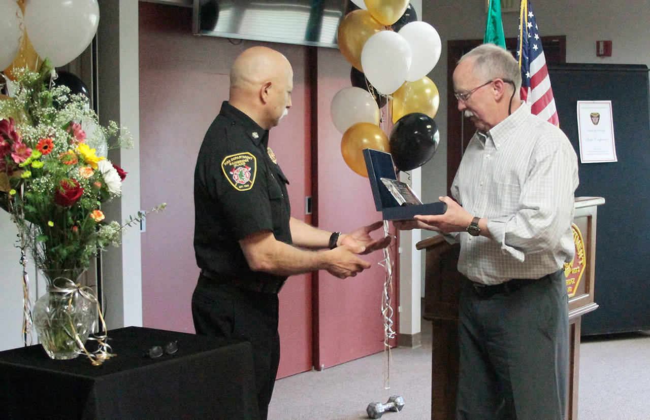 Luciano Marano | Bainbridge Island Review - Bainbridge Island Fire Department Chief Hank Teran presents retiring fire marshal Luke Carpenter with an award Wednesday. Carpenter capped a 29-year career in the fire service earlier this month, with his last day officially being May 1.