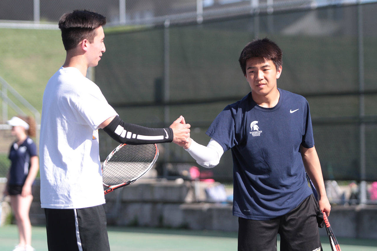 John Tappen congratulates his Spartan doubles teammate Ryan Wilson after they won a set against their Lakeside opponents. (Brian Kelly | Bainbridge Island Review)