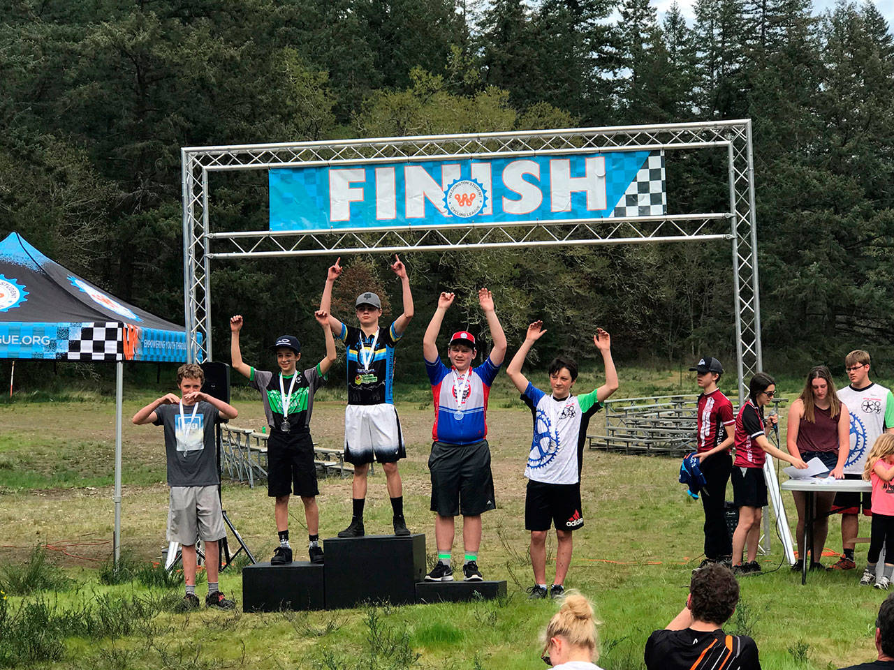 Middle school team rider TJ North (far right) of the Gear Grinders celebrates his medal at the finish line.