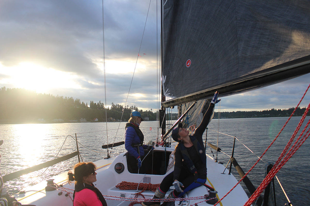 Kelly Danielson pushes out the boom to try to catch more wind as the crew turns to sail back into the marina on Thursday, May 21. The team goes out two to three times per week to practice the mechanics but say the team has really “gelled” together. Photo by Emily Gilbert.