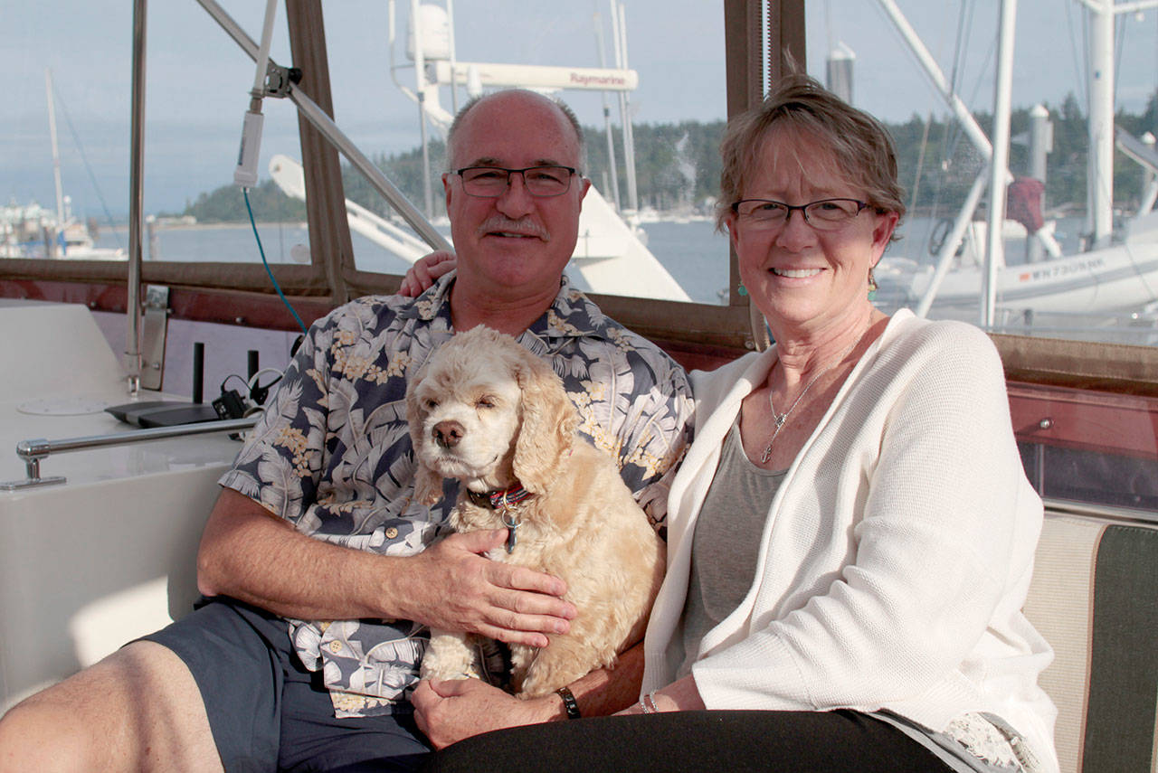 Luciano Marano | Bainbridge Island Review - Scott and Laurie Isenman aboard their boat with their dog Teddy.