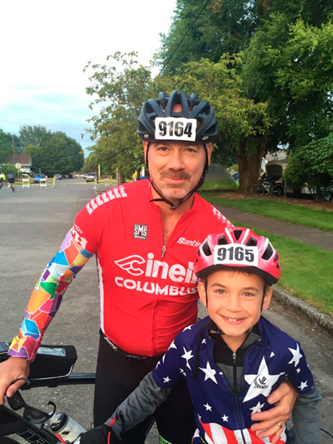 Photo courtesy of Kim Ring | Jeffrey Rogers and his son Julian, 10, during a recent ride. The young cyclist has racked up more than 500 miles in various group rides since 2015, all while struggling with serious hearing loss.