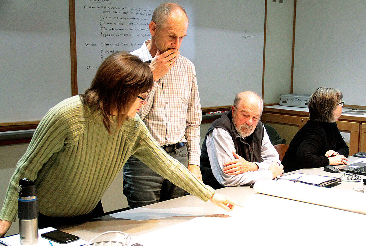 Architect Charlie Wenzlau, center, watches as Jane Rein, a member of the Design Review Board, asks about the original site plans for the hotel property on Hildebrand Lane. (Brian Kelly | Bainbridge Island Review)