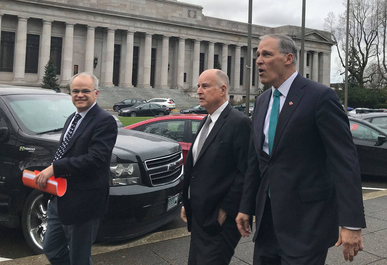 Former California Governor Jerry Brown, middle left, and Washington Governor Jay Inslee, middle right leave the Legislative Building in Olympia on Thursday. The two met with Democratic leadership and planned to have dinner at the Governors Mansion to discuss environmental policy with more than 70 state lawmakers, according to Inslee. (Photo by Emma Scher, WNPA Olympia News Bureau)