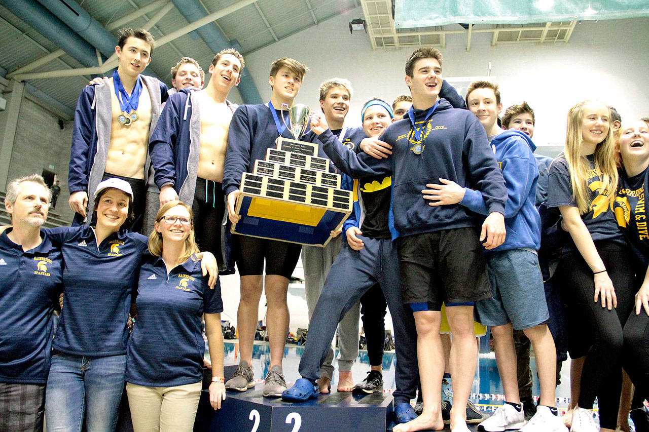 The Bainbridge Spartans swim & dive team gather on the medalists’ platform with the 3A state championship trophy. (Brian Kelly | Bainbridge Island Review)