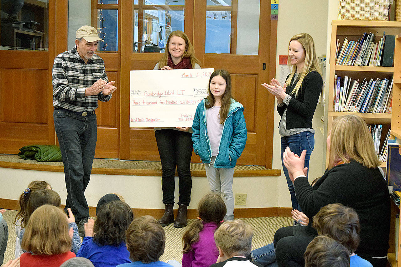 Margaret Coulter, a fifth-grader at The Island School, stands with Ray Victurine, land trust board president, Sinclair Ball, land trust community engagement associate, fifth-grade teacher Amanda Walker, as she presents a check to the Bainbridge Island Land Trust for its Stand for the Land fundraiser.                                (Photo courtesy of the Bainbridge Island Land Trust)