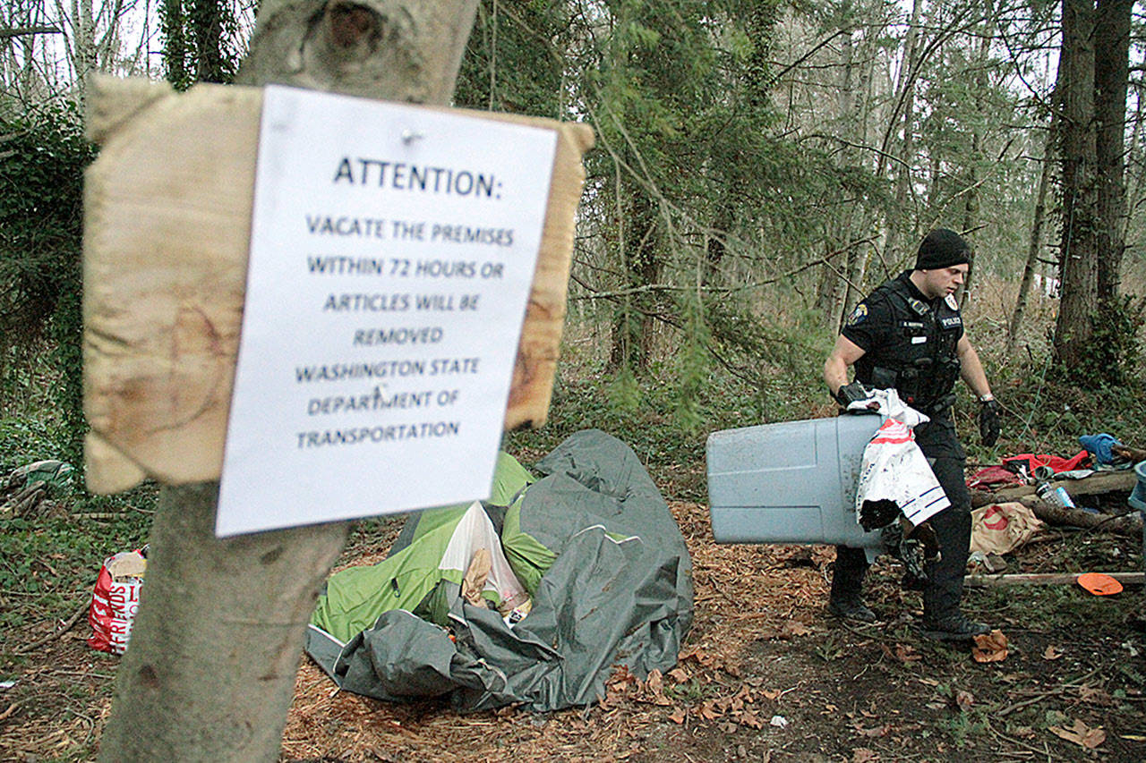 Bainbridge police clean up the remains of a homeless camp near High School Road in late Feburary. Cases of “unsheltered homelessness” have risen in the past year, according to a recent county survey on the number of homeless people in Kitsap.(Brian Kelly | Bainbridge Island Review)