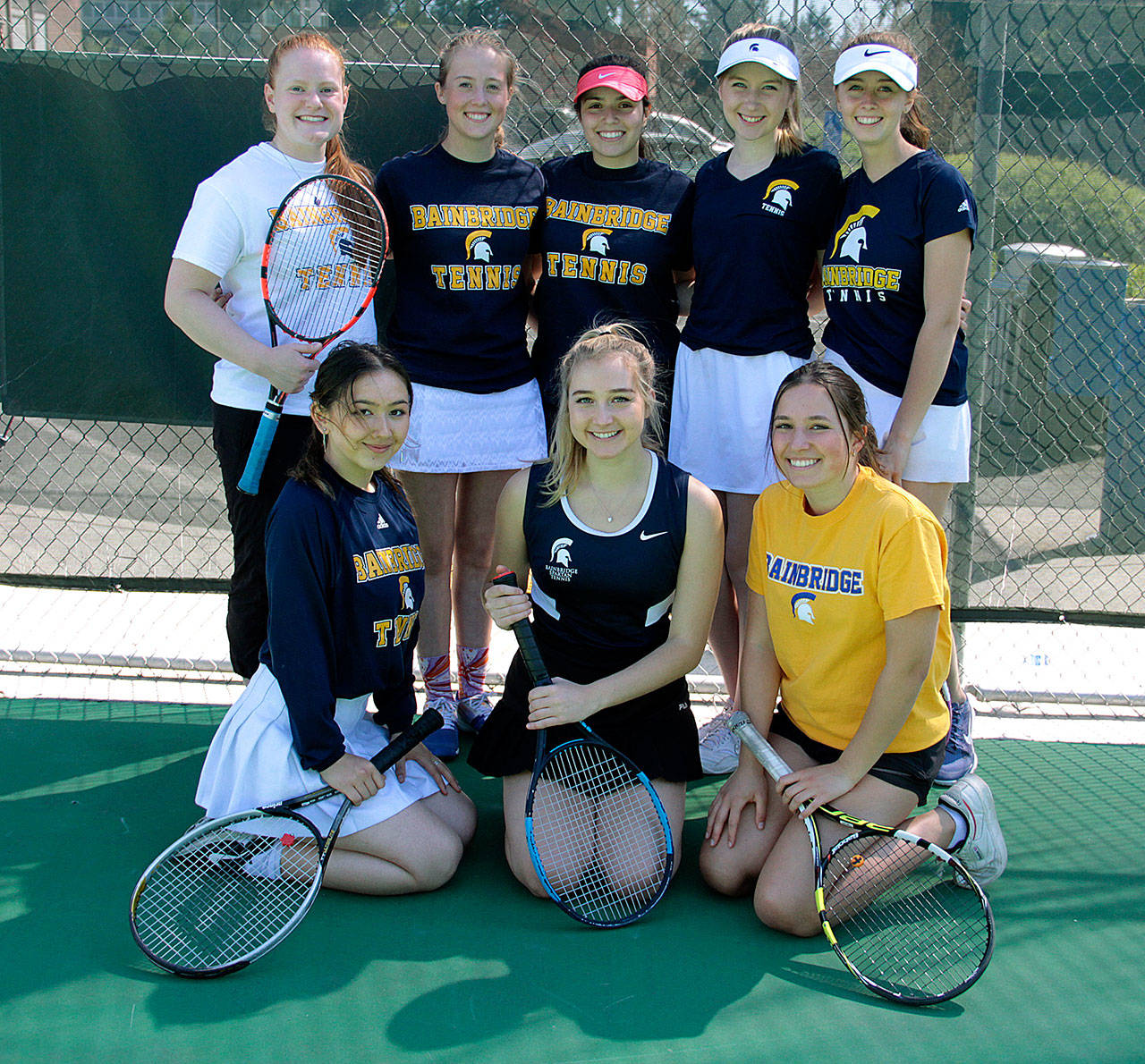The Bainbridge Spartans girls varsity tennis team gathers for a group photo before the start of the Metro tournament. In front are Jessica Pecunies, Madison Culp and Lina Klinkenberg; and in back, Marianne Milander, Matty Dunham, Jillian Abullarade, Lindsay Payne and Catherine Rolfes. (Brian Kelly | Bainbridge Island Review)