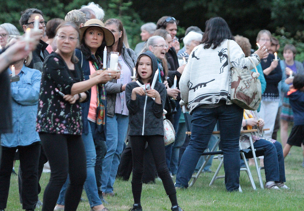 A large crowd gathers next to Highway 305 outside Seabold Methodist Church for a “Lights for Liberty” candlelight vigil to protest government detention camps at the country’s southern border. (Brian Kelly | Bainbridge Island Review)