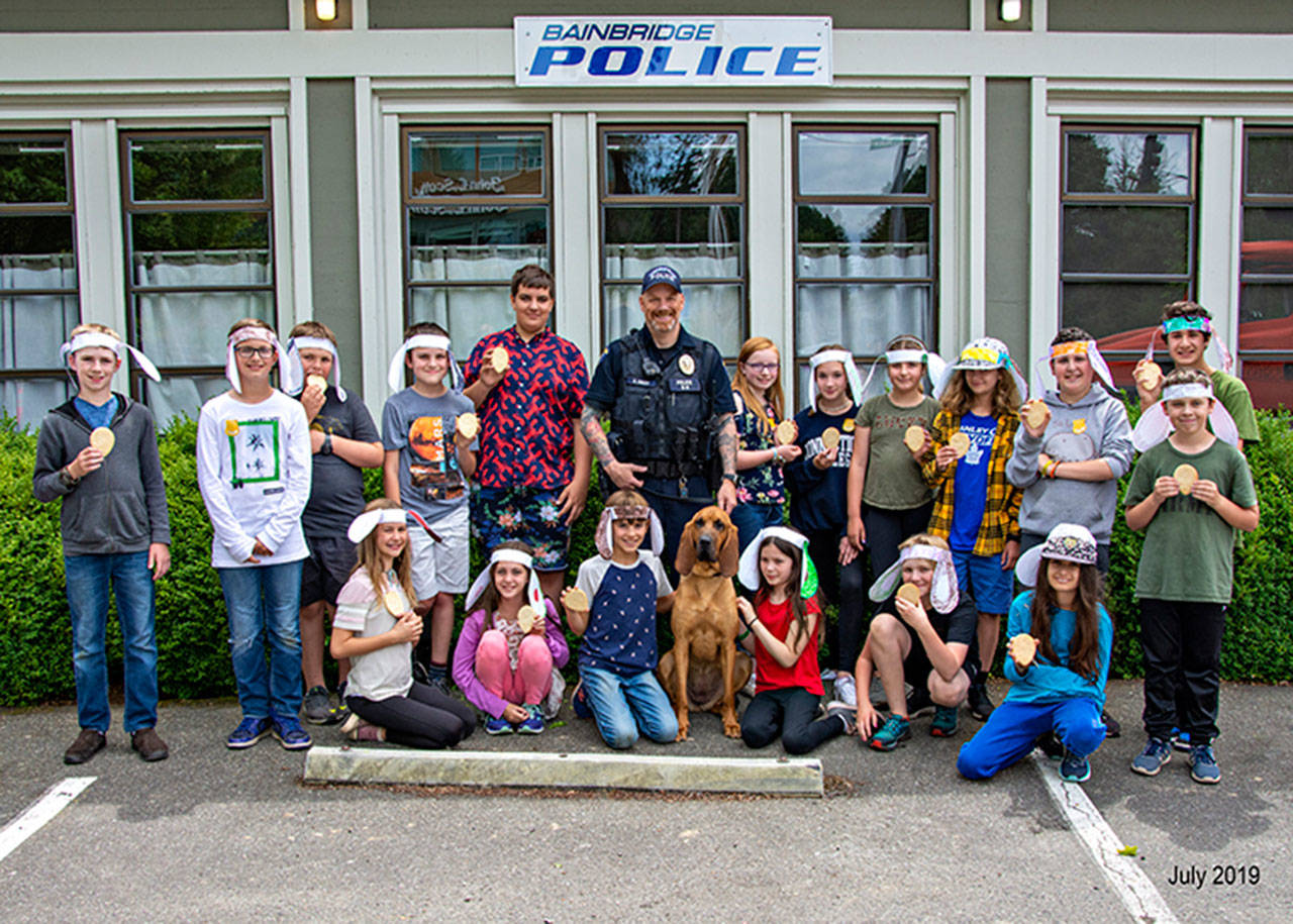 Pat Engaas photo | The latest group of Cops & Kids Camp attendees gather with Bainbridge Island Police Department K9 Officer Whitney and her human parter Officer Kurt Enget outside the station.