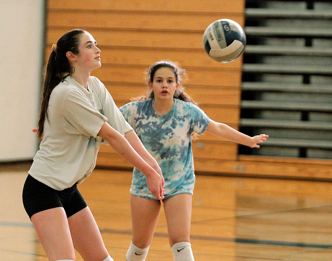 Olivia Van Ness passes while teammate Florencia Olivera watches during Spartan volleyball practice in Paski Gymnasium. (Brian Kelly | Bainbridge Island Review)