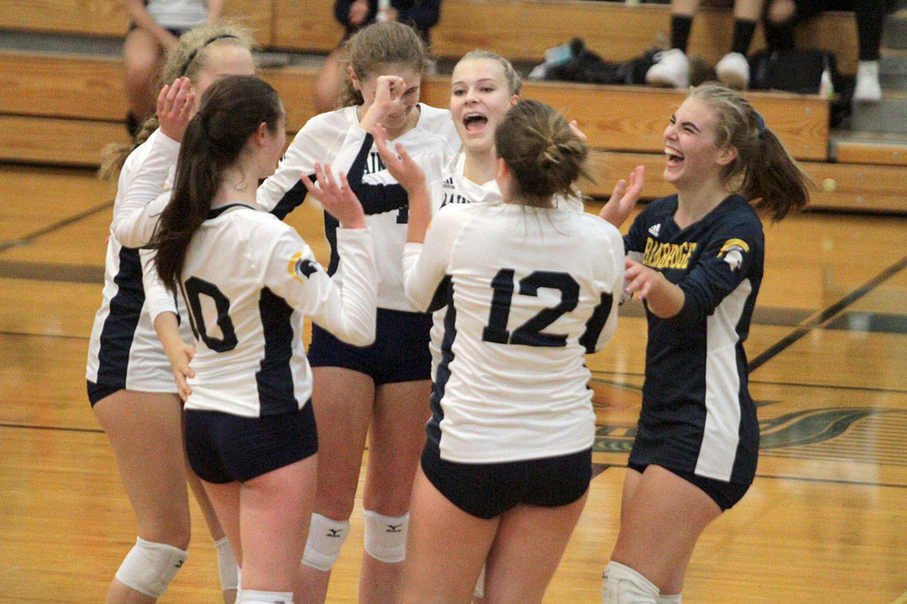 The Spartans celebrate after winning a rally in the second set against the Bulldogs. (Brian Kelly | Bainbridge Island Review)